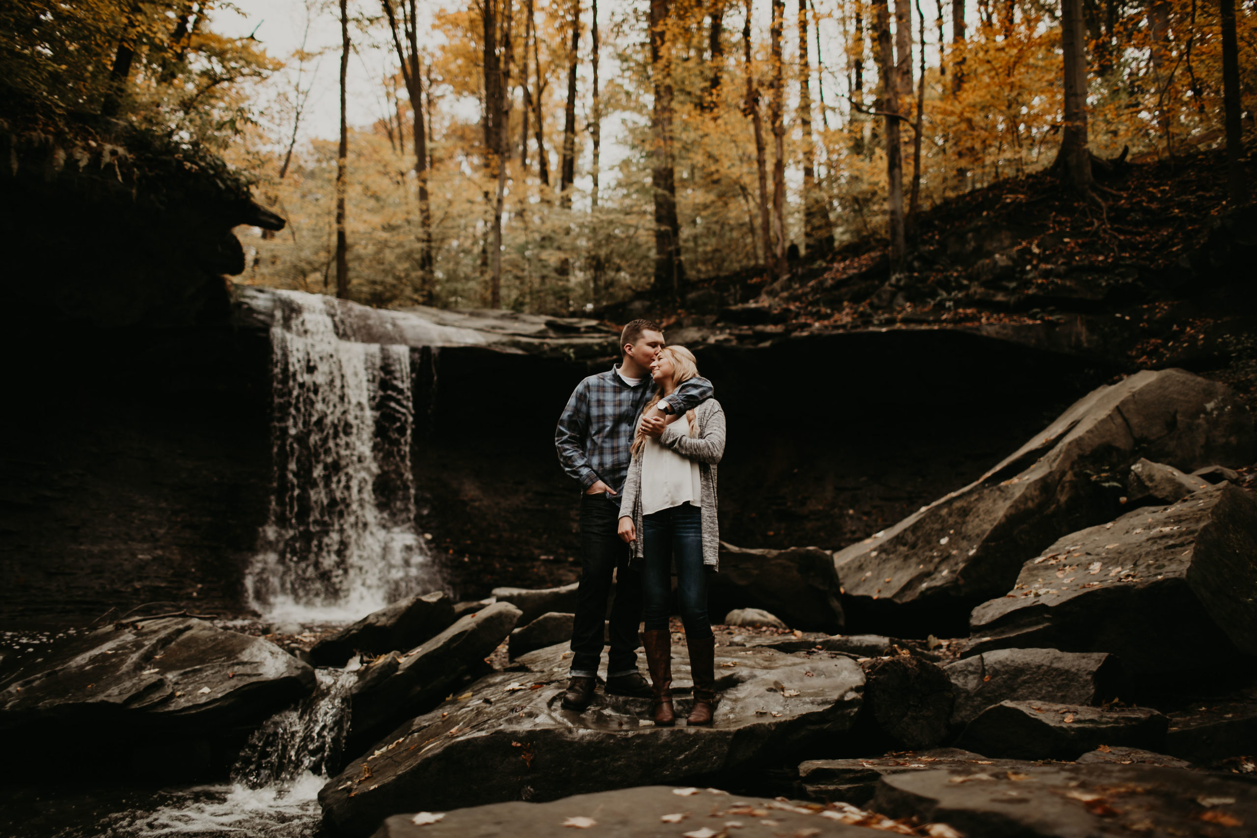Couple on top of a waterfall kissing in Cuyahoga Valley National Park in the fall