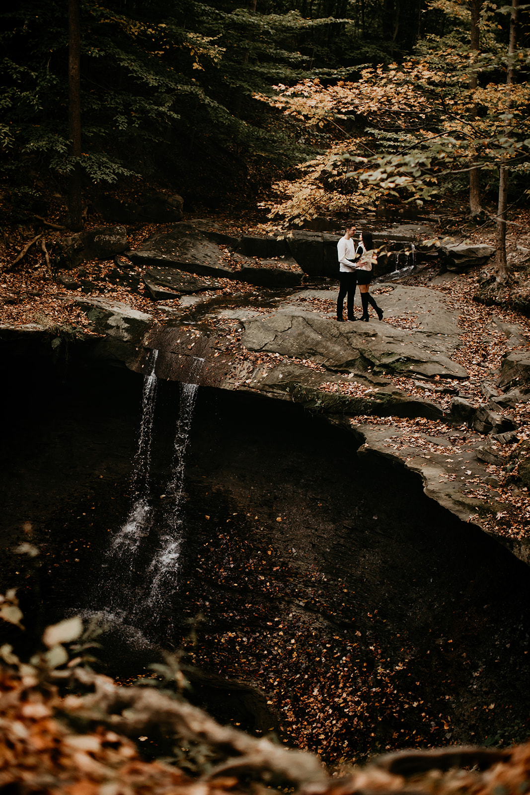 Couple on top of a waterfall kissing in Cuyahoga Valley National Park in the fall