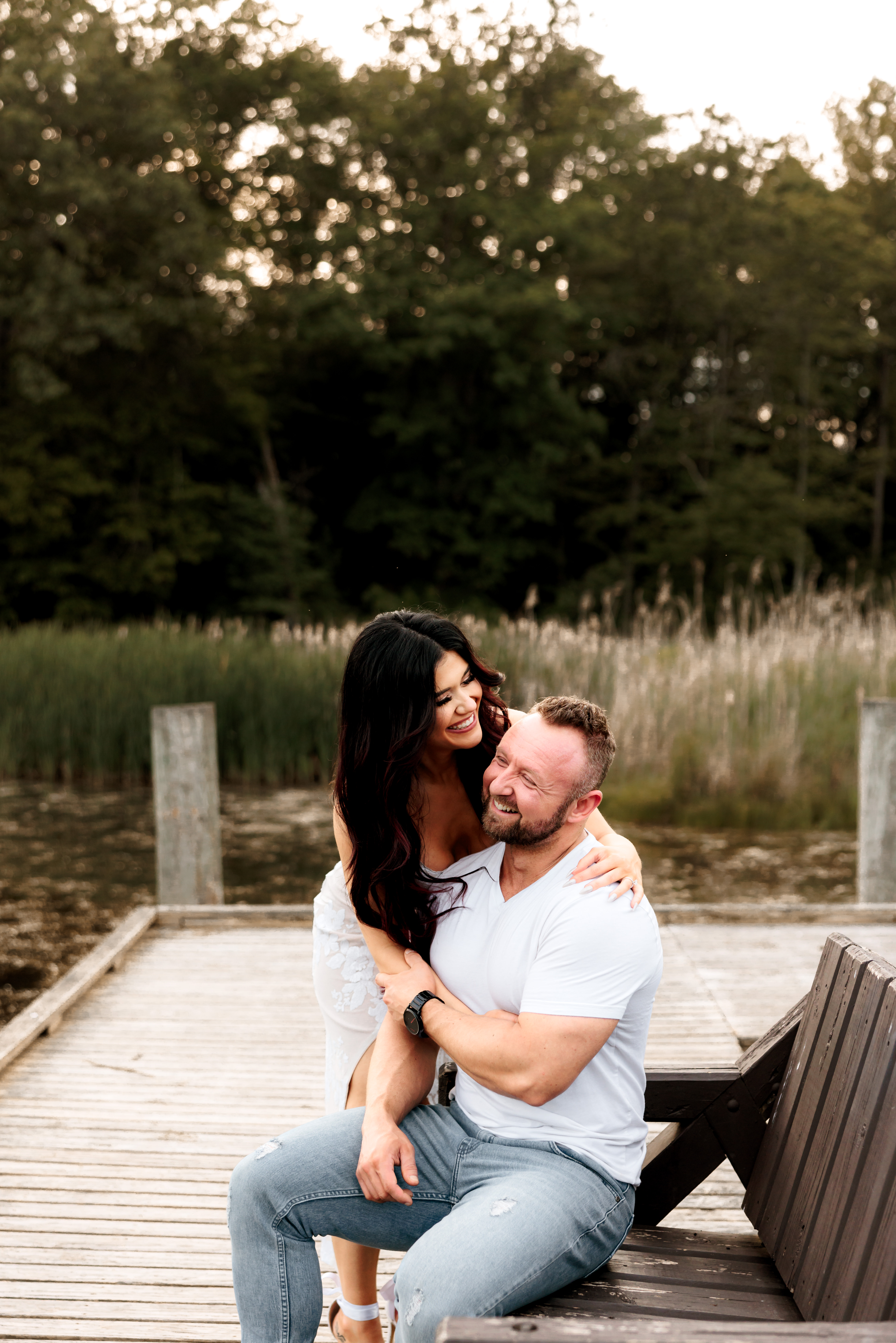 A picture taken in Cuyahoga Valley National Park of a couple laughing together on a doc for their engagement session.